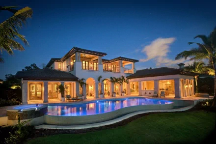 HD wallpaper of a luxury house with modern architecture, featuring warm lighting and an illuminated pool, set against a twilight sky.