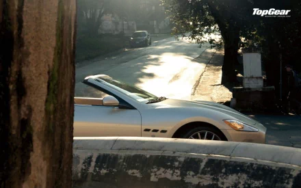 A sleek silver convertible parked on a sunlit street, surrounded by trees, showcasing the essence of the TV show Top Gear in this HD desktop wallpaper.
