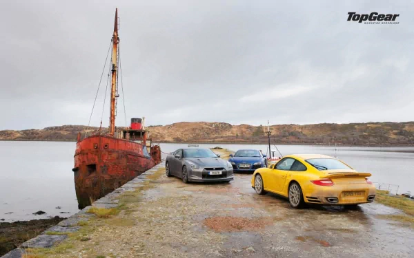 HD desktop wallpaper from Top Gear featuring two sports cars parked beside a rusty ship on a cloudy waterfront.