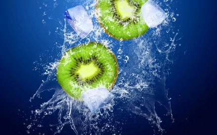 HD desktop wallpaper featuring fresh kiwi slices and ice cubes splashing in clear water against a vibrant blue background.