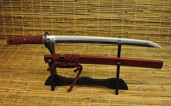 Man-made katana sword on a black display stand with red handle and scabbard against a bamboo mat — 4K Ultra HD PC desktop wallpaper and background.