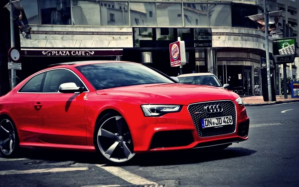 HD PC desktop wallpaper featuring a sleek red Audi RS5 parked on a city street in front of a café.