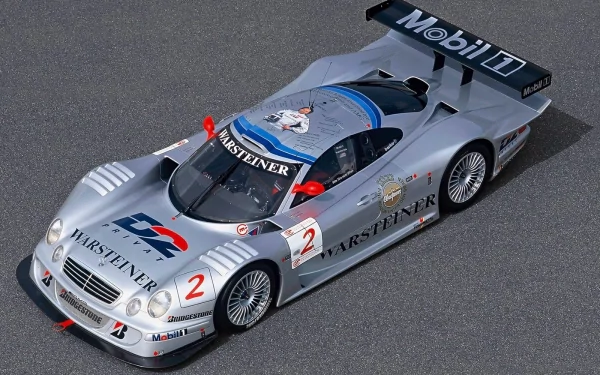 HD PC desktop wallpaper featuring a sleek silver Mercedes-Benz CLK GTR race car with Warsteiner and Mobil 1 branding, showcasing its aerodynamic design and detailed livery.