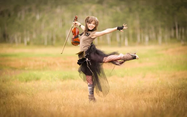 Lindsey Stirling dances gracefully in a field, holding a violin, captured in a vibrant 4K Ultra HD music-themed desktop wallpaper and background.