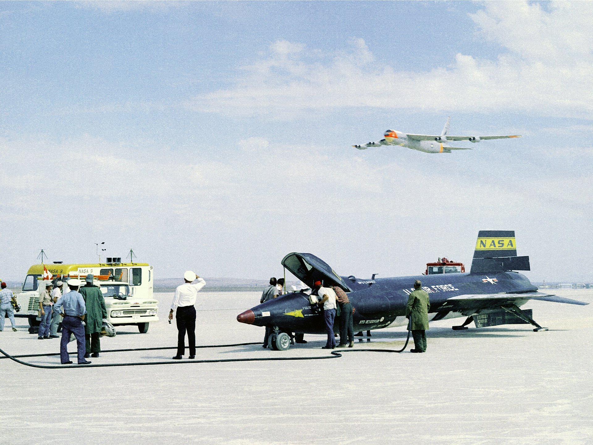 HD desktop wallpaper featuring the North American X-15 military aircraft on the ground with personnel and a NASA support plane in the background.