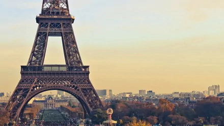 A stunning HD desktop wallpaper featuring the iconic Eiffel Tower, framed against a warm sunset, showcasing the beauty of man-made architecture in Paris.