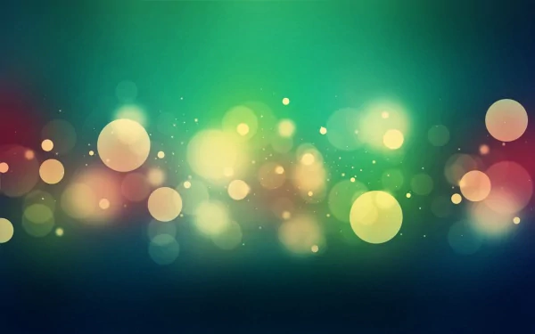 Artistic bokeh HD PC desktop wallpaper featuring soft multicolored light orbs and blurred glowing spots in green, teal, yellow and red over a dark gradient background.