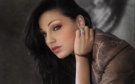 HD PC desktop wallpaper features a close-up portrait of singer Anna Tatangelo with soft lighting, highlighting her expressive gaze and elegant style in a music-themed image.