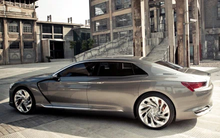 HD desktop wallpaper showcasing a sleek silver Citroën DS9 parked in an urban industrial setting.