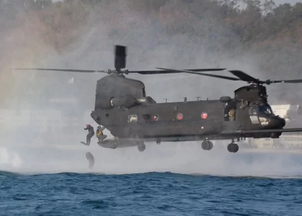 HD desktop wallpaper featuring a military Boeing CH-47 Chinook helicopter hovering over water with personnel rappelling down.