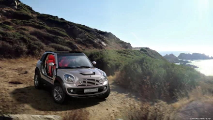 2009 Mini Beachcomber concept on a coastal dirt trail overlooking cliffs and the ocean under a bright sky — HD PC desktop wallpaper/background.