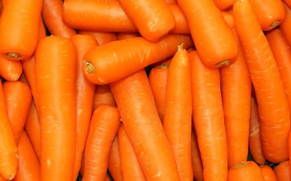 An HD desktop wallpaper featuring vibrant orange carrots stacked together, highlighting their fresh color and vegetable appeal.
