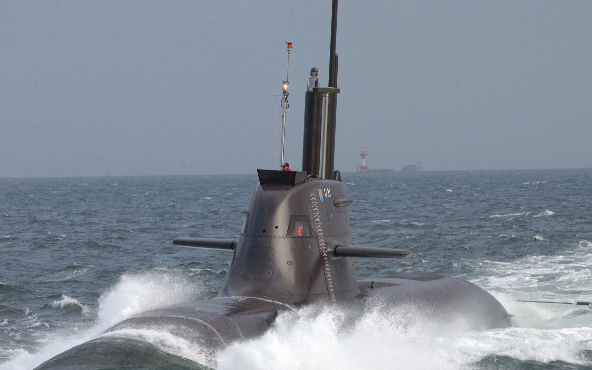 HD PC desktop wallpaper depicting a military submarine cutting through ocean waves under a clear sky.