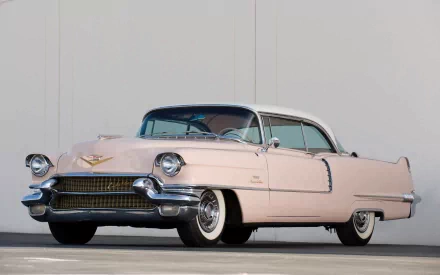 HD PC desktop wallpaper: pink 1956 Cadillac Sixty-Two Coupe DeVille, low-angle shot on concrete displaying chrome trim and whitewall tires.