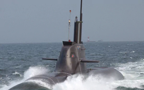 HD PC desktop wallpaper depicting a military submarine cutting through ocean waves under a clear sky.