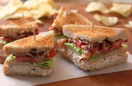 A delicious assortment of sandwiches made with fresh ingredients, presented as a high-definition desktop wallpaper, complemented by a background of potato chips.
