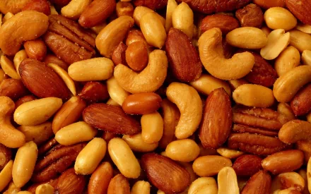 A close-up of a colorful assortment of nuts, showcasing various shapes and textures, set against a rich backdrop for an appealing HD PC desktop wallpaper and background.