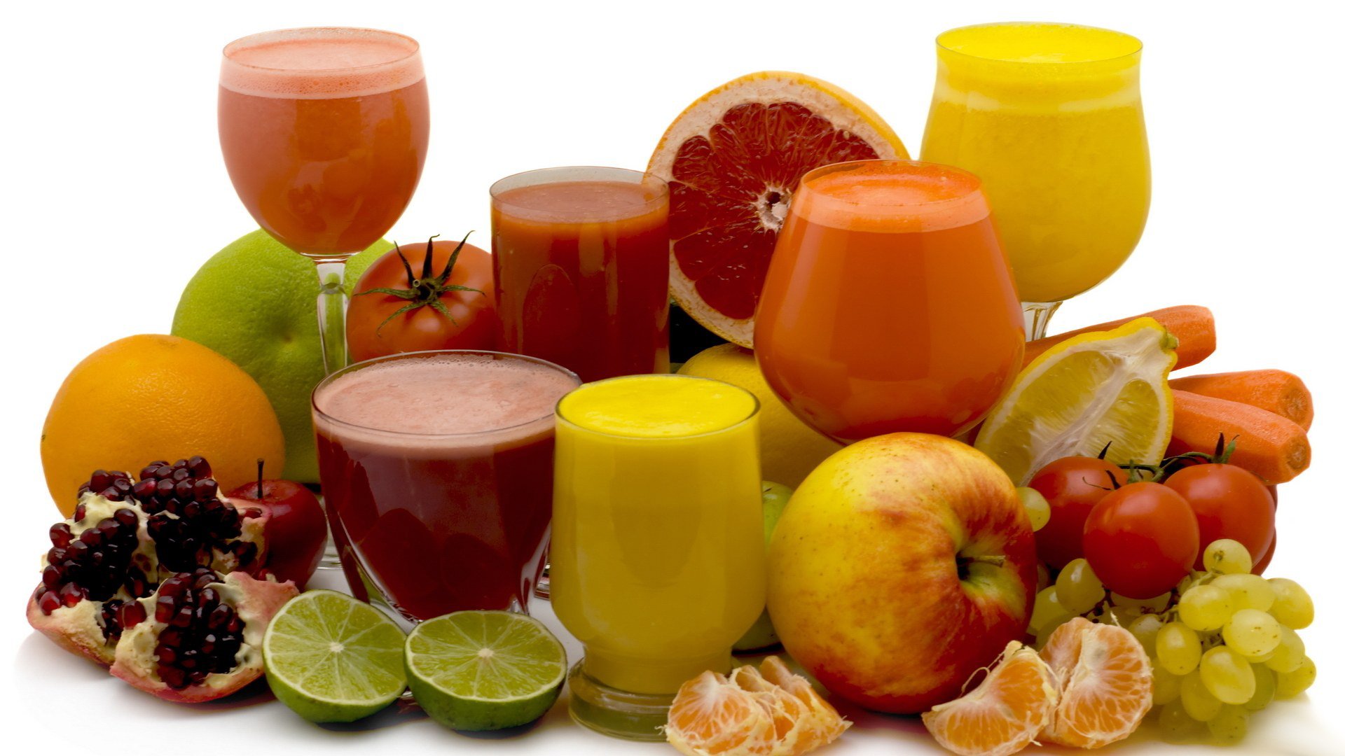 HD PC desktop wallpaper and background of food: assorted fruit and colorful juices — apples, oranges, citrus halves, pomegranate, grapes, and glasses of orange, yellow, and red juice.