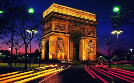 A stunning HD wallpaper featuring the illuminated Arc de Triomphe against a twilight sky, with vibrant light trails from passing vehicles enhancing the scene.