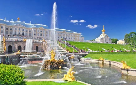 HD desktop wallpaper featuring the man-made Peterhof Palace with its grand fountains and lush green gardens under a clear blue sky.