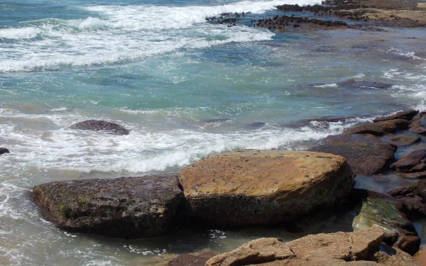 Seascape of ocean waves crashing onto rocky coast at Cronulla Beach, Sydney, Australia, captured in a high-definition nature photography for desktop wallpaper.
