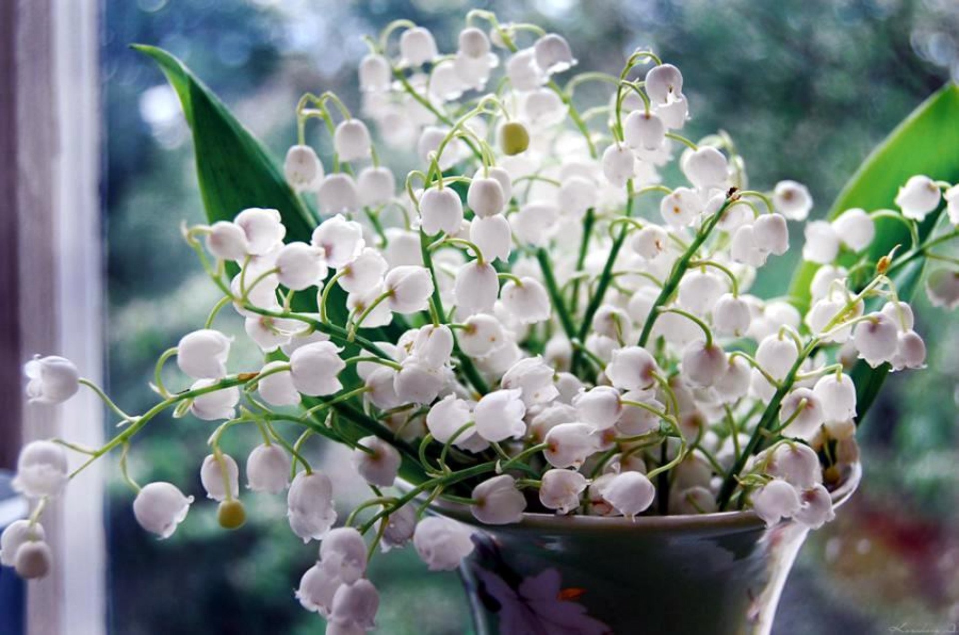 HD desktop wallpaper featuring a close-up of white lily of the valley flowers arranged in a vase against a softly blurred background.