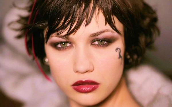 HD PC desktop wallpaper featuring a close-up portrait of celebrity Olga Kurylenko with striking makeup and a small tattoo near her right eye.