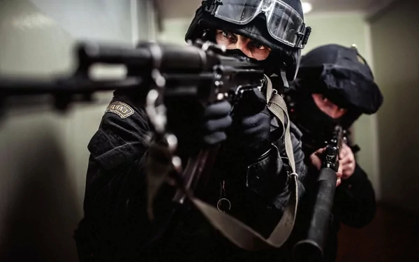A dramatic HD wallpaper featuring armed SWAT team members in tactical gear, poised and focused as they navigate a corridor, embodying intensity and precision in a military context.