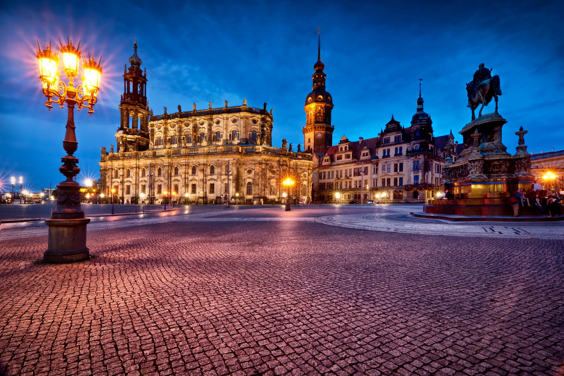 HD PC desktop wallpaper of Dresden, Germany: illuminated man-made monuments and baroque architecture at dusk on a cobblestone square with ornate lamps.