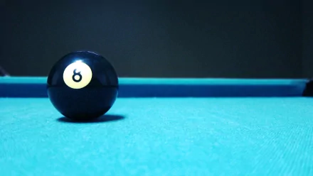 HD PC desktop wallpaper featuring a close-up of the black 8-ball on a blue pool table, highlighting the man-made elements of the classic pool game.