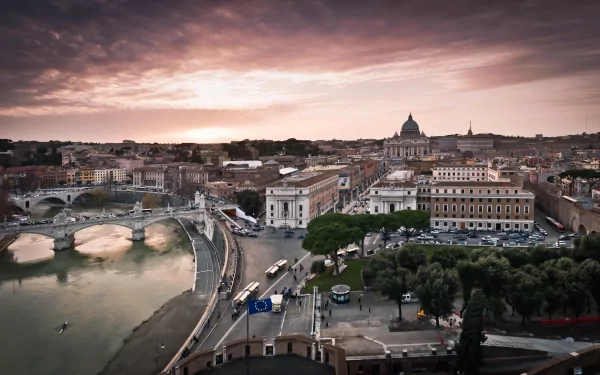 A stunning HD wallpaper showcasing Rome's iconic architecture at sunset, featuring the Tiber River and St. Peter's Basilica in the distance, capturing the city's vibrant atmosphere.
