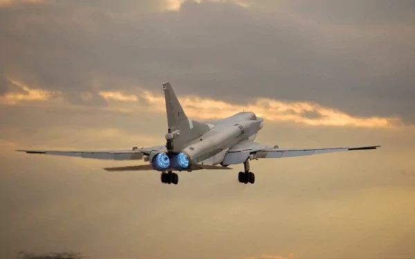 HD desktop wallpaper showing a military Tupolev Tu-22 jet fighter taking off against a dramatic cloudy sky at sunset.