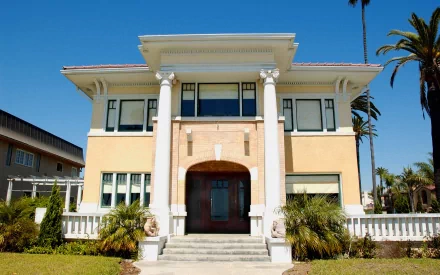 HD desktop wallpaper showing a man-made villa with classical columns, large windows, and a clear blue sky in the background.