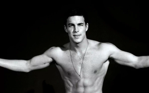 HD desktop wallpaper featuring a shirtless Mario Casas against a black background, highlighting his toned physique and confident expression.