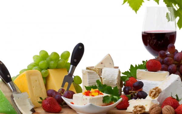 A vibrant 4K Ultra HD desktop wallpaper featuring an assortment of cheeses, green and red grapes, strawberries, walnuts, and a glass of red wine on a white background.