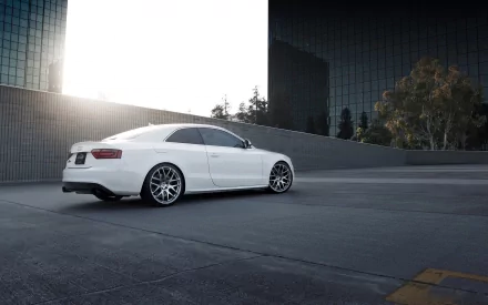 HD PC desktop wallpaper featuring a sleek white Audi S5 parked in an urban setting with modern glass buildings and bright sunlight.
