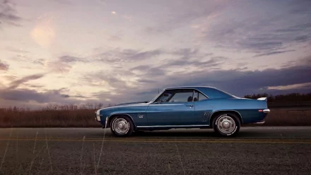 HD PC desktop wallpaper featuring a blue Chevrolet Camaro SS parked on a road under a cloudy sky at dusk.