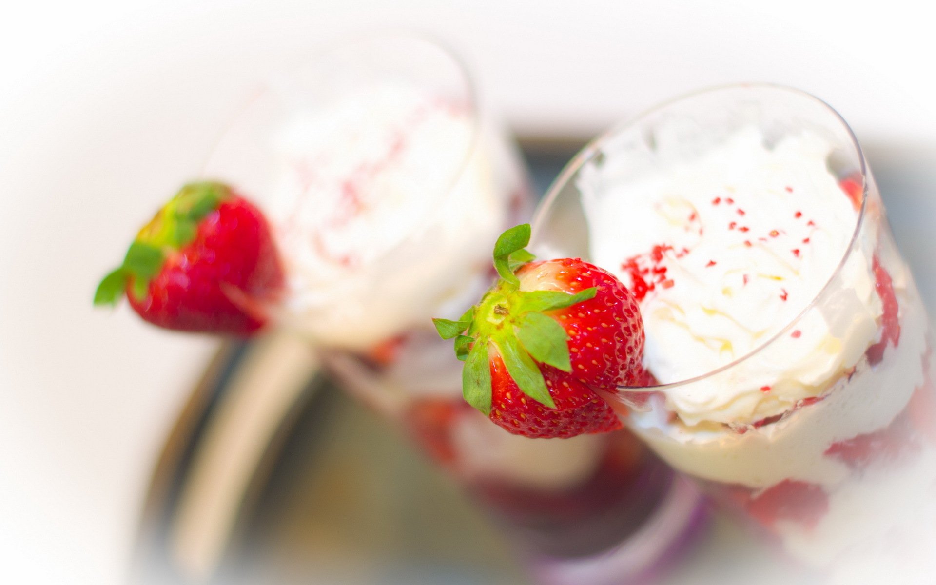 HD PC desktop wallpaper featuring a close-up of two dessert glasses with whipped cream and fresh strawberries, highlighting vibrant colors and food textures.