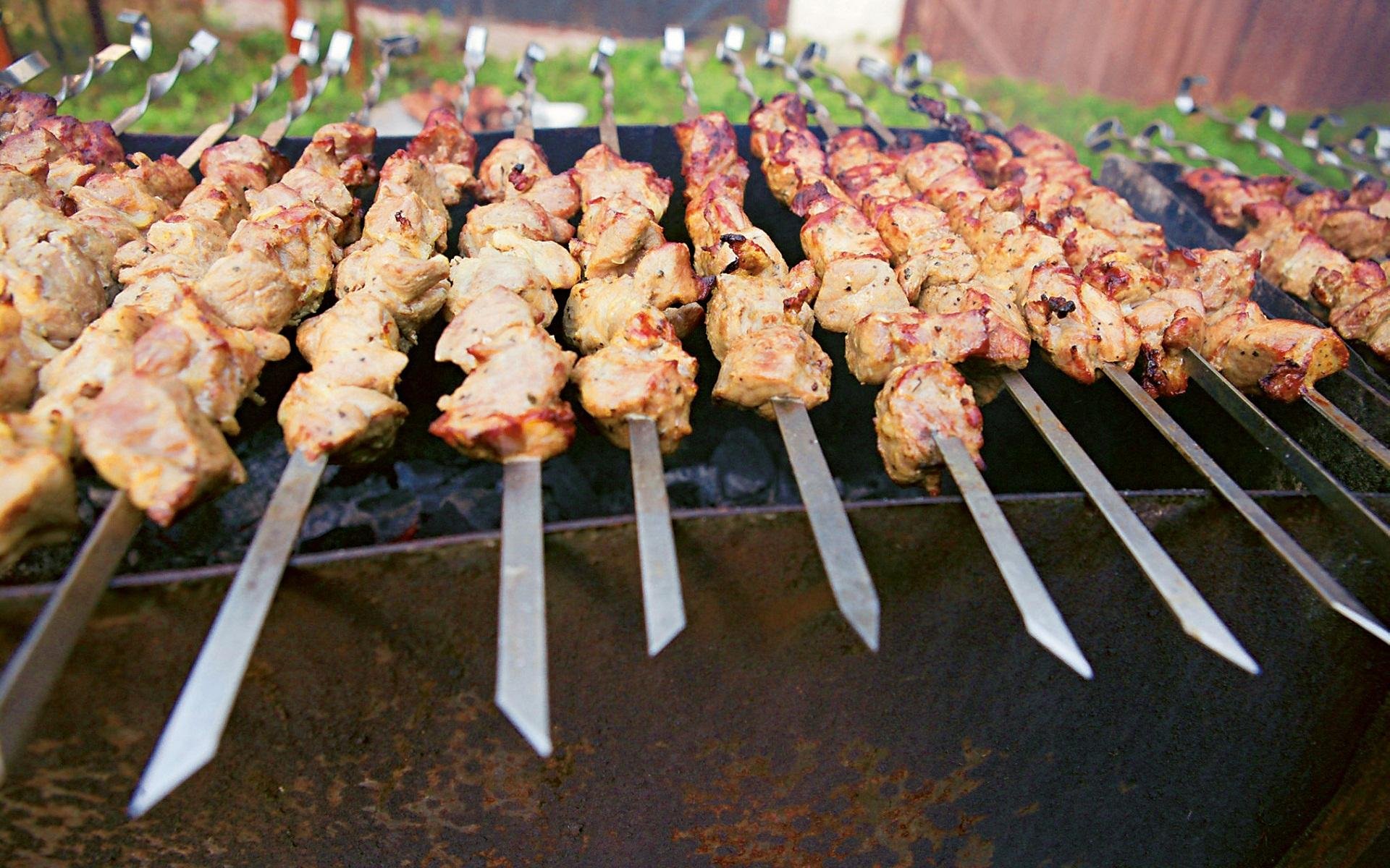 HD PC desktop wallpaper showing close-up of skewered meat grilling over charcoal barbecue.