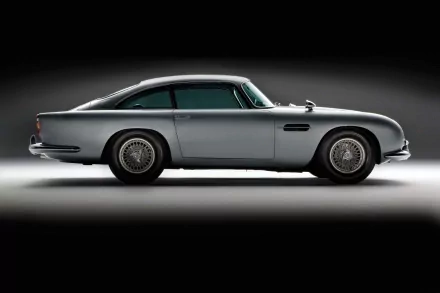 Sleek silver Aston Martin DB5 showcased in a high-resolution 4K Ultra HD desktop wallpaper, highlighting the classic vehicle's elegant design against a dark background.
