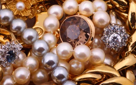 Close-up of man-made jewelry featuring pearls, gold pieces, and sparkling gemstones, captured in high definition as a PC desktop wallpaper and background.