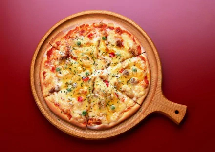 A delicious pizza topped with cheese and herbs, served on a wooden platter, against a vibrant red background. This HD image makes a tempting desktop wallpaper.