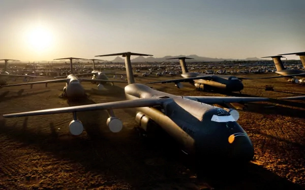 HD desktop wallpaper showcasing a fleet of military Lockheed C-5 Galaxy aircraft parked on a sunlit airfield at dawn.