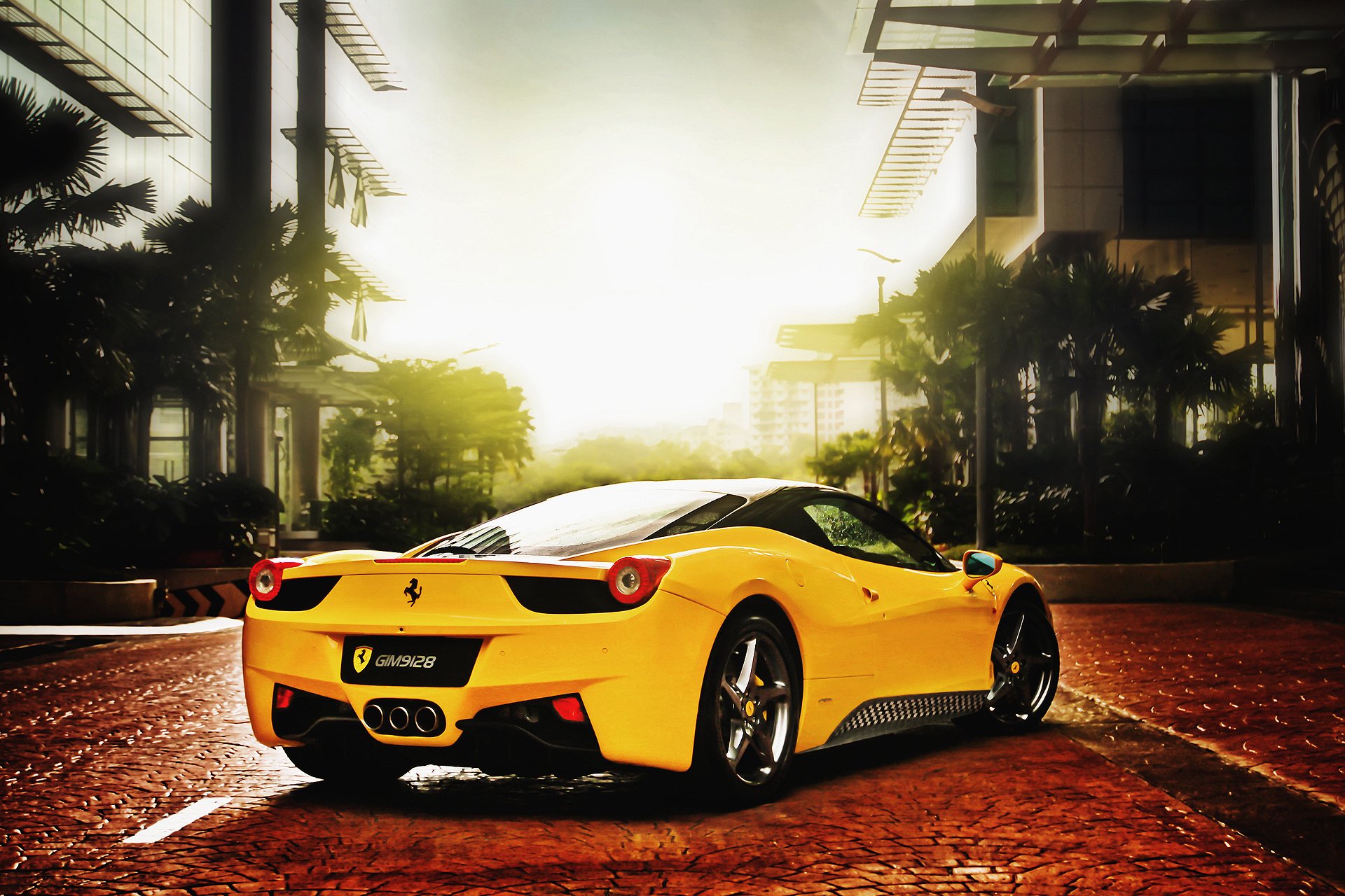 HD desktop wallpaper featuring a yellow Ferrari parked on a sunlit, palm-lined street with modern buildings in the background.