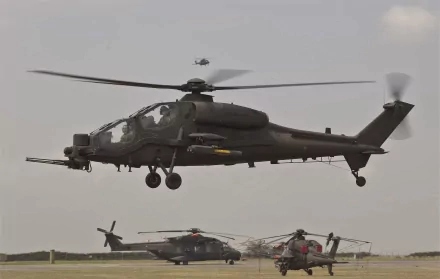 Agusta A129 Mangusta military helicopter in flight over a runway, captured in 4K Ultra HD for a PC desktop wallpaper background.