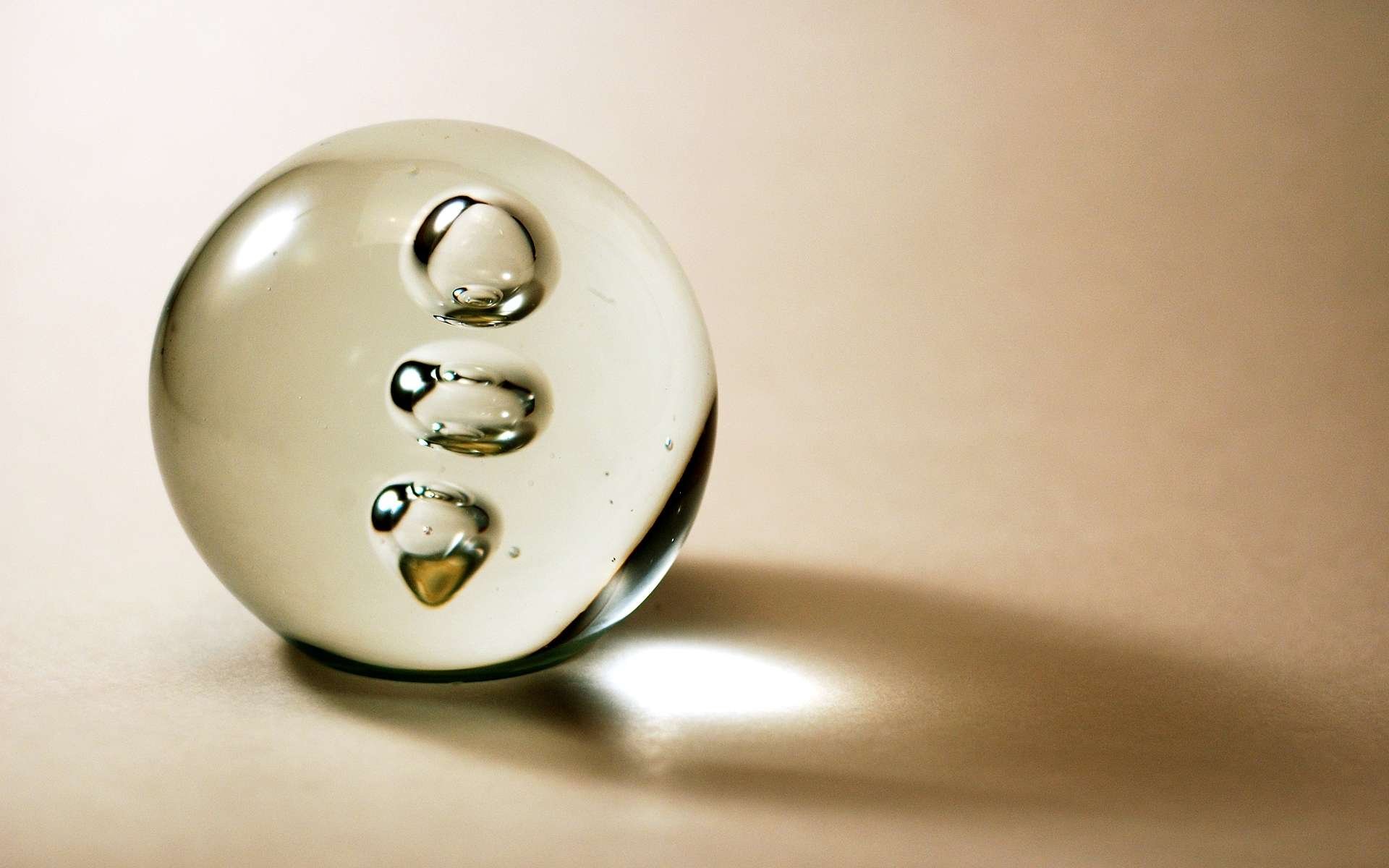 HD PC desktop wallpaper featuring an abstract transparent sphere with smaller bubbles inside, set against a soft beige background.