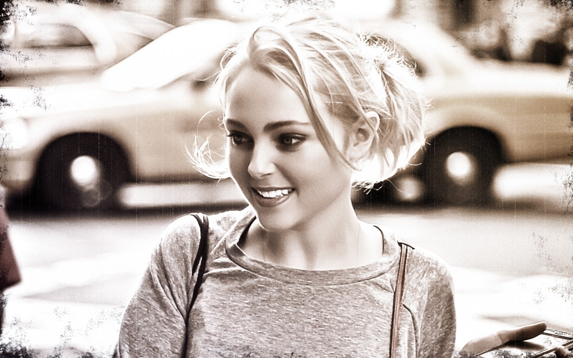 HD PC desktop wallpaper featuring a smiling Annasophia Robb with a soft, blurred background in a candid, monochrome style.