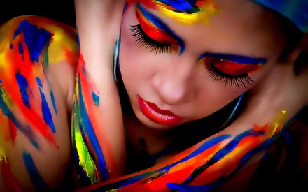 HD PC desktop wallpaper of a woman with vibrant, colorful body painting and bold makeup, capturing artistic expression and vivid detail.