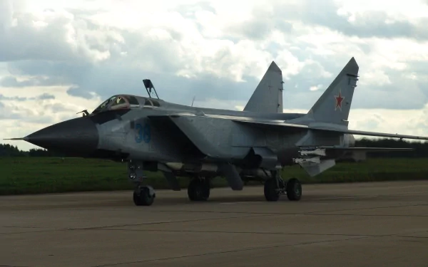 HD desktop wallpaper featuring a Mikoyan MiG-31 military aircraft on a runway under a cloudy sky.