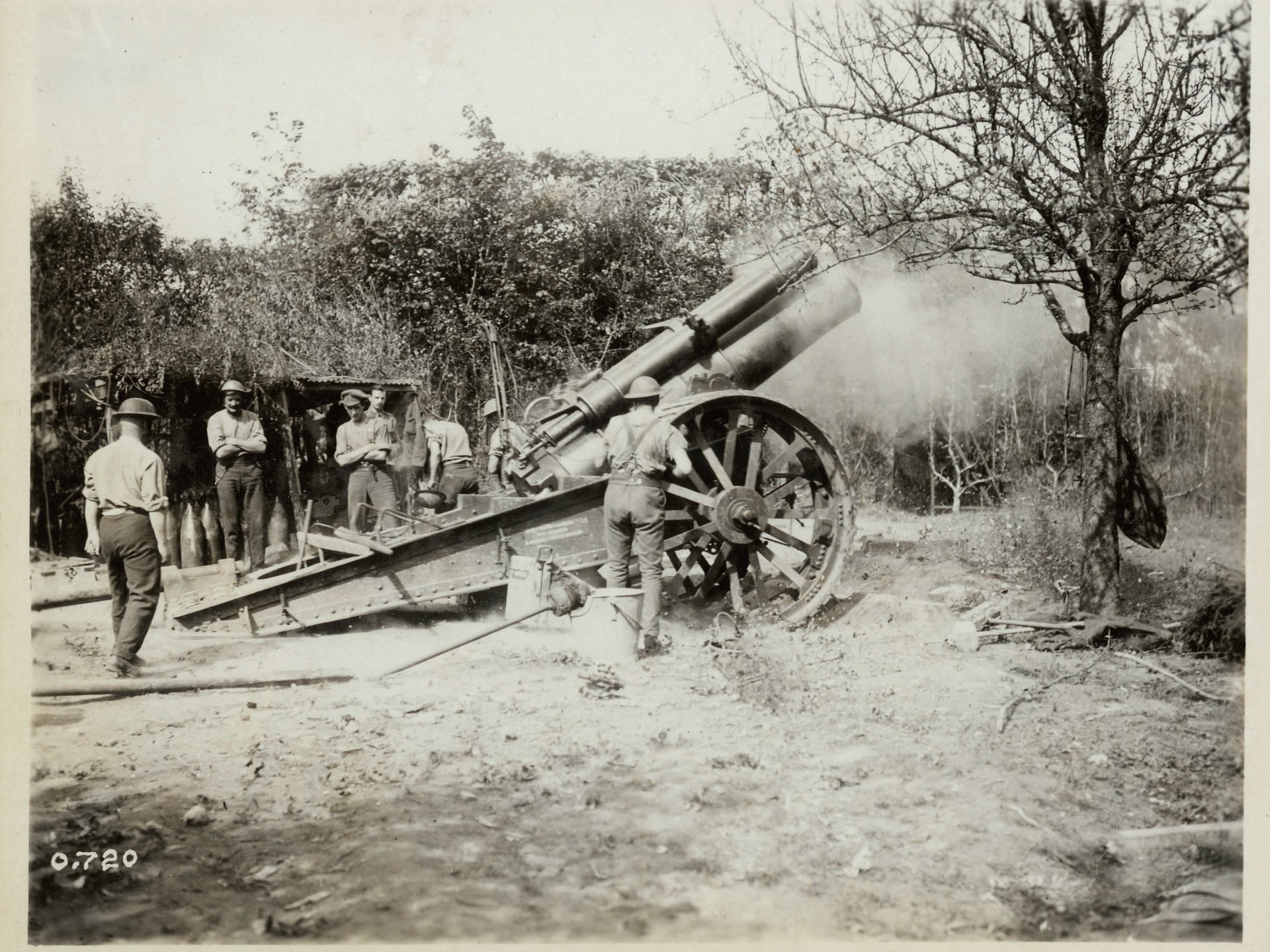 Sepia wartime scene: military artillery crew operating a large field gun — 2K Quad HD PC desktop wallpaper/background.